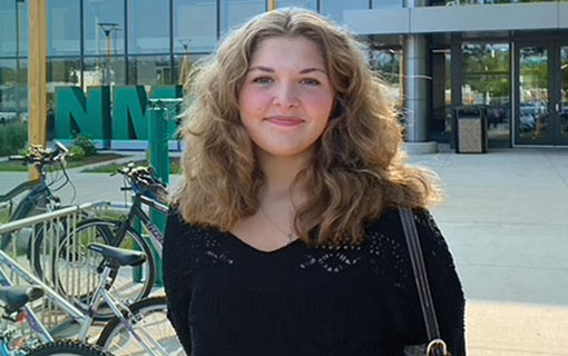 An NMC student in front of the Timothy J. Nelson Innovation Center