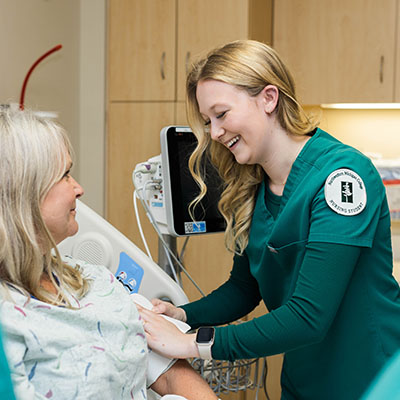 An NMC nursing program student in a hospital with a patient