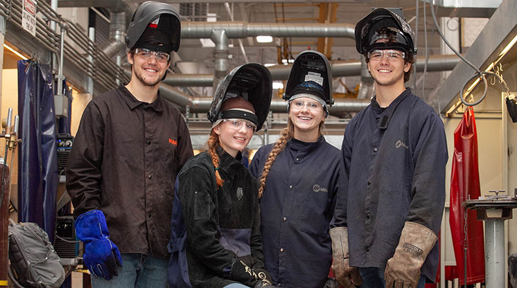 NMC welding program students pose in their welding masks