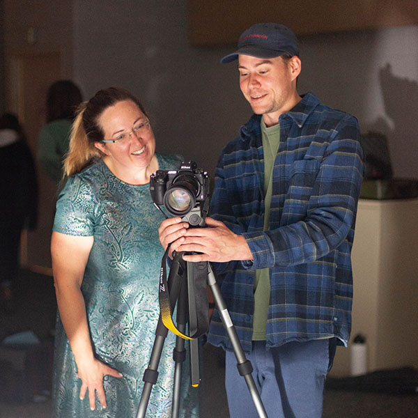 An NMC Visual Communications instructor and student look at a camera