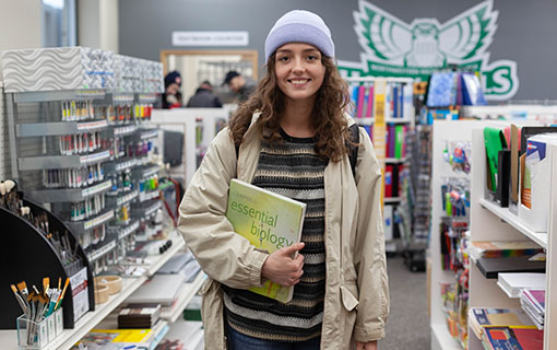 An NMC student holding a notebook in the bookstore