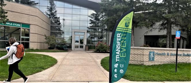 Student walking by transfer event flag